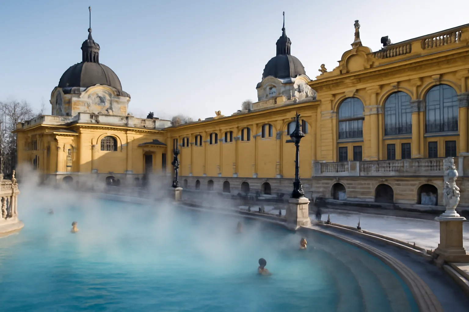 Bassin extérieur des bains Széchenyi à Budapest en hiver, vapeur s&#39;élevant de l&#39;eau thermale, façade néo-baroque jaune en arrière-plan, quelques baigneurs